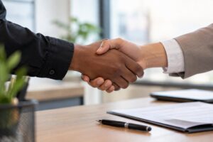 Aperto de mãos selando uma contratação, representando a decisão de RH baseada em fatos reais sobre incentivos fiscais para PCD